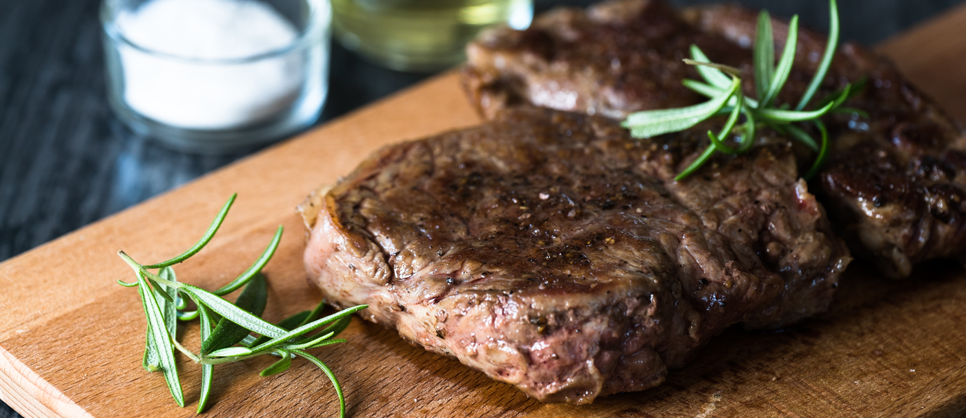 steak sur plaque de bois et romarin